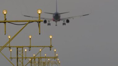 Son yaklaşan uçak, karanlık gökyüzünün altında parlak pist ışıkları ile hizalandı.