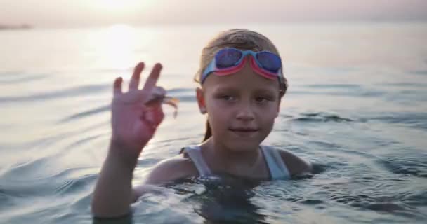 Girl Swimming Goggles Stands Sea Water Sunset Holding Small Crab — Stock Video