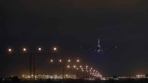 带着起落架的飞机接近跑道 跑道进近灯光明亮 与夜空相对照 — 图库视频影像