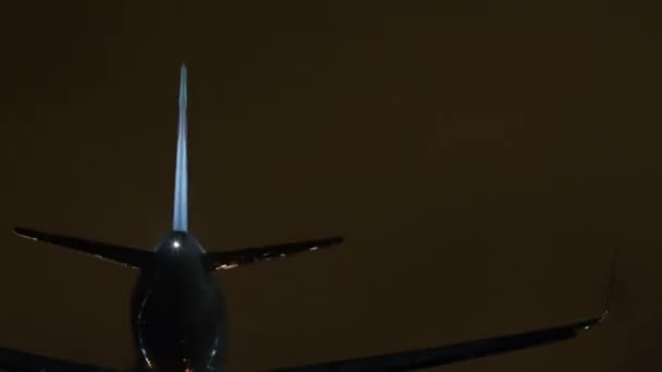 夜空の下に明るい滑走路ライトに囲まれた着陸ライトを搭載した飛行機 — ストック動画