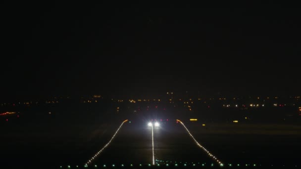 滑走路に沿って飛行機が加速し 夜空に持ち上げられる — ストック動画