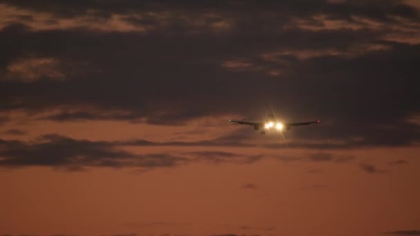 Airplane Visible Landing Lights Flies Evening Sky Orange Hues Cloud — Stock Video