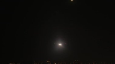 İniş ışıkları olan iki uçak birbiri ardına havaalanına iniş yapmak için iniş yapıyor.