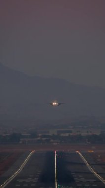 Alacakaranlık inerken havalanan ve yere inen uçakların dikey video zaman atlaması