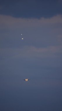 İniş sırasındaki üç uçağın karanlık bir gökyüzüne karşı dikey videosu.