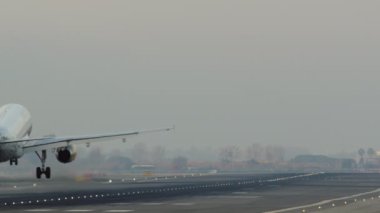 Uçak, havaalanındaki aydınlık piste indikten sonra hareket etmeye devam ediyor.