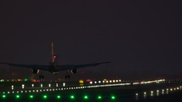 Airplane Touches Runway Glow Vibrant Nighttime Lights — Stock Video