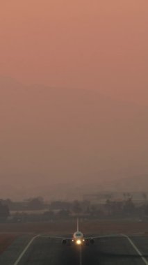 Navigasyon ışıkları açık bir şekilde havalanan bir uçağın dikey videosu