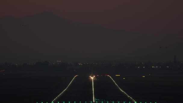飛行機は夕方に照らされた滑走路から上昇します — ストック動画