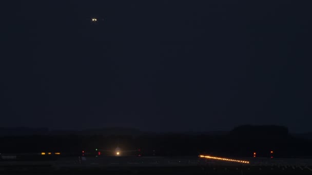 Самолет Поднимается Взлетно Посадочной Полосы Яркими Огнями Время Другой Готовится — стоковое видео