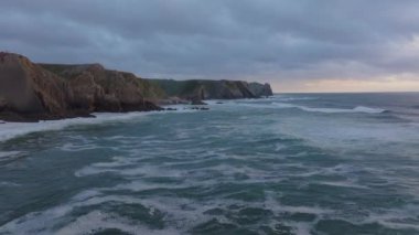 Rocky sahili geriye doğru uçan bir dron ile Portekiz, Atlantik okyanusundaki kayalara çarpan dalgaları yakalıyor.