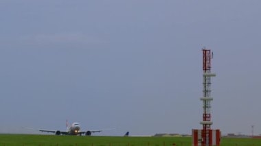 LISBON, PORTUGAL - 25 Nisan 2024: Bir ticari uçak TAP Air iniş için yaklaşıyor, havaalanı arazisindeki bir navigasyon kulesine yakın bir yerden geçiyor