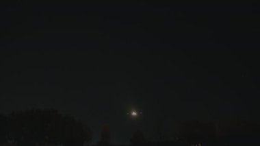 Karanlıkta üstümüzden geçen uçak seyrüsefer ışıkları parlıyor.