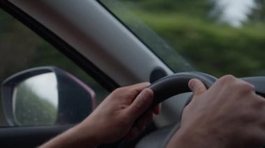 Eller direksiyona yakın ve yan ayna dışarıdaki çevreyi yansıtıyor.