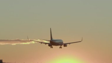 Gün batımında iniş takımları açık bir şekilde piste yaklaşır.