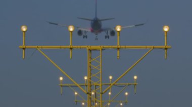 Çerçeve merkezli uçak, iniş takımları yerleştirildi, iniş pisti yakındaki ışıkları geçerek alçalıyorlar.