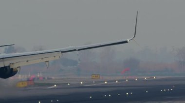 Rhine Air uçağı yavaş çekimde iniş takımlarıyla akşam ışığında piste yaklaşıyor.