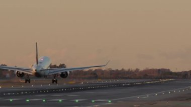 İniş takımlı uçak pistin üzerinde ışıklarla dolu.