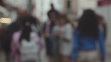 Şehir hayatının dinamik hareketini bulanık bir görüntü yakalıyor tanınmayan figürler ve Bokeh ışıkları kentsel bir atmosfer yaratıyor.