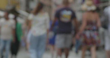 Şehir caddesinde yürüyen, hareketliliği ve kentsel çevrenin yoğun doğasını vurgulayan bulanık bir görüntü.