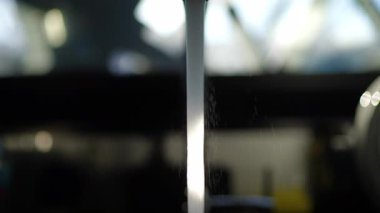 Akan musluk suyu akıntısı arka planda görünür damlacıklar ve mutfak arka planında güçlü bir şekilde yakalanır.