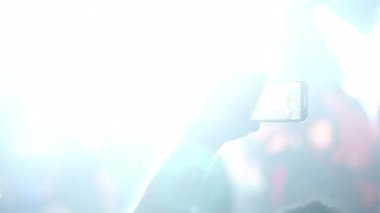 Akıllı telefonlu canlı müzik konseri canlı sahne ışıklarına karşı duran dijital teknoloji ve kişisel tutku ile dinamik performans anını yakalayan hayran.
