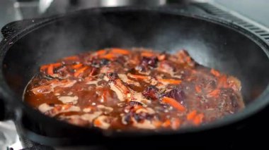 Et ve havuç kaynatıyorlar, aromatik buharı kırsal dökme demir tencereye salıyorlar, sağlıklı mutfak pişirme sürecini zengin mutfak sıcaklığı ve geleneksel lezzetle yakalıyorlar.