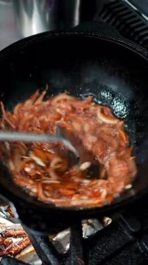 Yetenekli şef tavada altın sarısı soğanları dikkatlice karıştırıyor, sıcaklığı ustalıkla yönetirken özel mutfak tekniğiyle zengin, karamelize tatlar üretiyor.