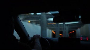 Sürücü, dışarıda bulanık ışıklar olan tünele yaklaşırken arabanın içinde direksiyon tutuyordu.