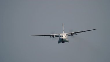 Çift pervaneli uçak, dönen pervaneleri net görebilen kameraya doğru uçuyor.