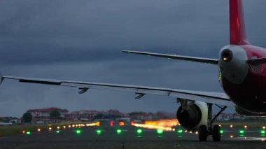 Arka planda ışıklandırılmış ışıklarla podyuma yerleştirilmiş uçak, havacılığın özünü yakıyor ve alacakaranlıkta yolculuk ediyor.