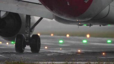 Şiddetli yağmur sırasında uçak iniş takımlarının ve motorun yakın görüntüsü