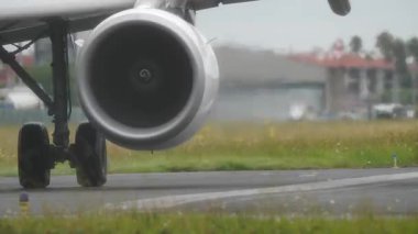 Bir uçak motoru ve iniş takımının pist üzerindeki yakın görüntüsü, mühendislik detayları ve havacılık tasarım unsurlarını vurguluyor