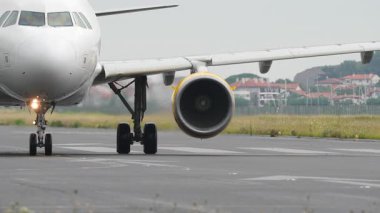 Görünür türbin dönüşüyle pistte ağır çekimde hareket eden ticari jetin yakın görünümü