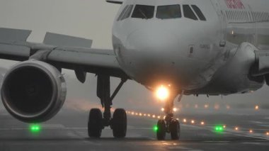 SAN SEBASTIAN, SPAIN - 1 AĞUSTOS 2025: İberya Airbus A320, San Sebastian Havalimanı 'ndaki şiddetli yağmur sırasında ıslak bir pistte taksicilik yapıyor.