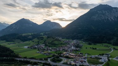 Avusturya 'nın Tyrol dağlarının arasına yerleşmiş Wiesing köyünü aydınlatan günbatımının hava manzarası huzurlu bir manzara yaratıyor.