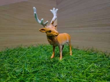 Sentetik çimlerde geyik şeklinde bir oyuncak.