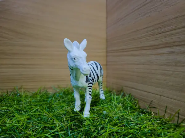 Sentetik çimlerin üzerinde zebra şeklinde bir oyuncak.