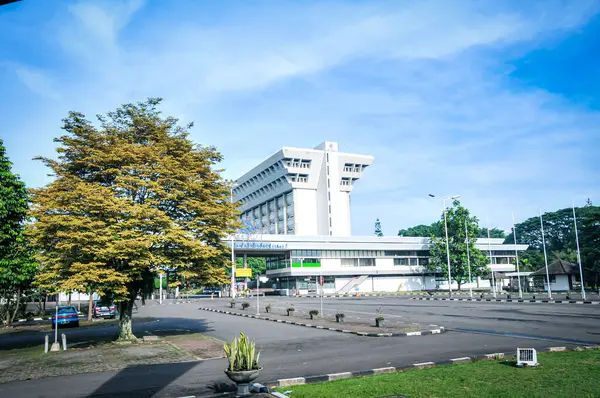 Açık mavi gökyüzünün altında beyaz bir bina görüldü.