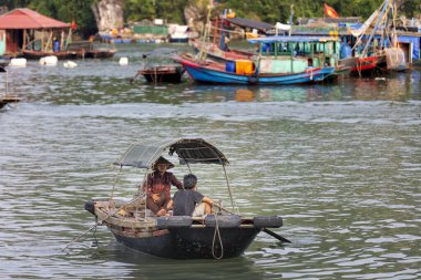 Vietnam 'da Ha Long Körfezi. Pazardaki balıkçılar deniz ürünleri, meyve, sebze ve atc sunuyorlar.