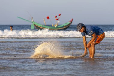 Balıkçı ve tekneleri denizde kumsalda