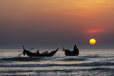 Balıkçı ve tekneleri denizde kumsalda