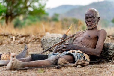 Dupa kabilesinin şefi Kamerun 'da av malzemeleriyle dinleniyor. Liderliğin, geleneğin ve atalarımızın çarpıcı bir portresi.