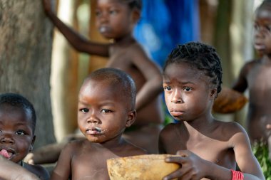 Dupa kabilesinin çocukları, Kamerun 'un kuzeyindeki bir köyde sıradan bir günde su kabağı kabağından basit bir yemeği paylaşırlar. Doğal yaşam, toplum ve gelenek