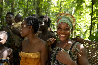 Kamerun 'daki Baka kabilesinin kadınları yağmur ormanlarında renkli elbiseler ve geleneksel yüz dekorasyonlarıyla neşeli bir anı paylaşıyorlar..