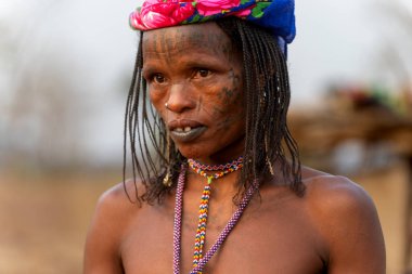 Geleneksel yüz dövmeleri ve boncuklu kolyesi olan, otantik Afrika kabilesi kimliği ve kültürel mirasını yansıtan Mbororo bir kadın..