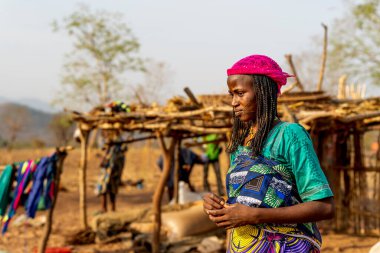 Mbororo kadını bebeğini renkli kumaşlarla taşıyor. Geleneksel bir Afrika köyünde anneliğin ve günlük yaşamın bir portresi..