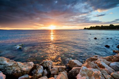 Hırvatistan 'ın Pag Adası' ndaki Mandre plajında sakin deniz ve Akdeniz cazibesiyle renkli bir gün batımı yaşanıyor..