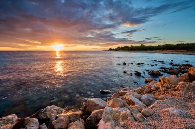 Hırvatistan 'ın Pag Adası' ndaki Mandre plajında sakin deniz ve Akdeniz cazibesiyle renkli bir gün batımı yaşanıyor..