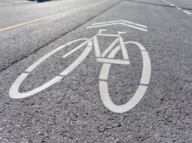 Yol işaretleri belirgin olarak belirlenmiş bisiklet şeritlerini vurgular, bisikletçileri güvenli ve güvenli bir şekilde gidip gelmeye teşvik eder